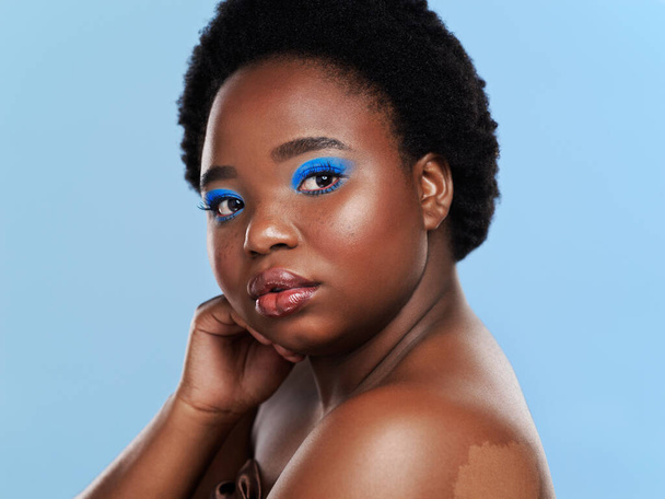 What makes you different makes you beautiful. Studio shot of a beautiful young woman posing against a blue background - Foto, Bild