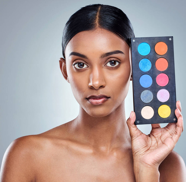 Kies je kleur. Gesneden portret van een aantrekkelijke jonge vrouw poseren in studio tegen een grijze achtergrond - Foto, afbeelding