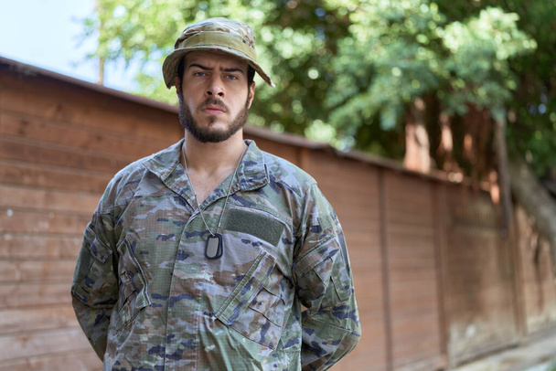 Giovane uomo ispanico indossa uniforme soldato in piedi al parco - Foto, immagini