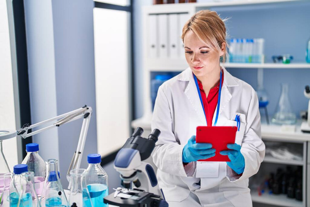 Young blonde woman scientist using touchpad at laboratory - Photo, image