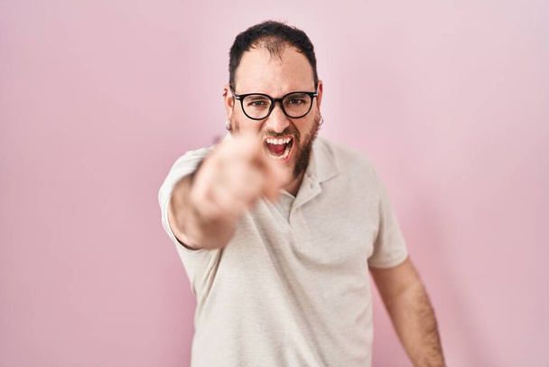 Plus size hispanic man with beard standing over pink background pointing displeased and frustrated to the camera, angry and furious with you  - Photo, Image