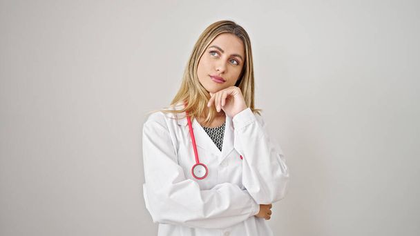 Young blonde woman doctor standing with doubt expression thinking over isolated white background - Φωτογραφία, εικόνα