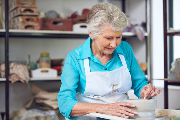 Κάνει αυτό που αγαπάει. μια ηλικιωμένη γυναίκα που φτιάχνει ένα κεραμικό δοχείο σε ένα εργαστήριο - Φωτογραφία, εικόνα
