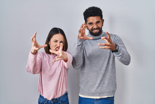 Νεαρό ζευγάρι ισπανόφωνων που στέκονται μαζί φωνάζοντας απογοητευμένοι από οργή, με χέρια που προσπαθούν να στραγγαλίσουν, φωνάζοντας τρελά  - Φωτογραφία, εικόνα