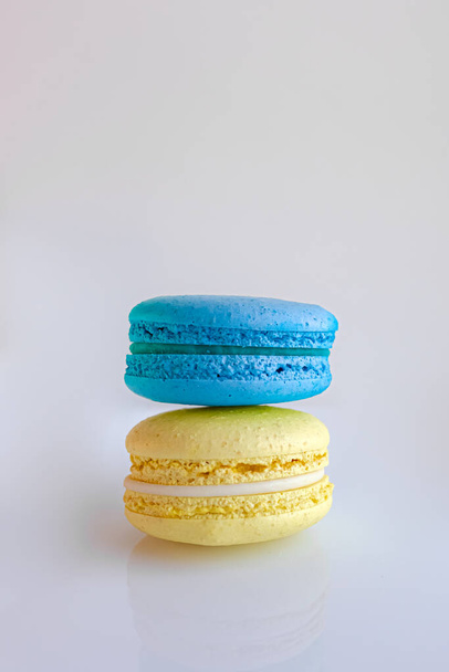 Colors of the flag of Ukraine. Blue-yellow symbols. Multicolored macaroons. Delicate French cookies. Coffee dessert. Cookies based on meringue. Crunchy crust. An appetizing still life. - Photo, Image