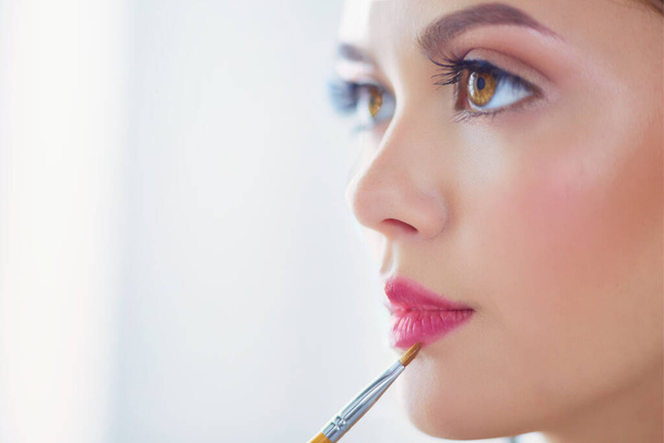 Beautiful girl with cosmetic powder brush for make up. Makeup. Make-up applying for perfect skin. - 写真・画像