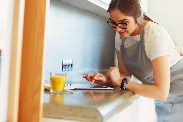 Portrait of young attractive caucasian brunette housewife at kitchen. Morning with cup of coffee and tablet pc. - Foto, Bild