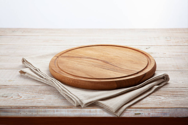 Empty pizza board and canvas tablecloth on white wooden deck. Selective focus. - Foto, Imagen