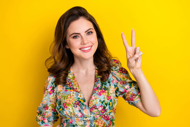 Photo of lovely positive girl beaming smile hand fingers demonstrate v-sign isolated on yellow color background. - Foto, Bild