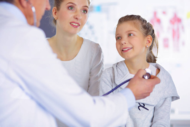 Girl and doctor with stethoscope listening to heartbeat. - Zdjęcie, obraz