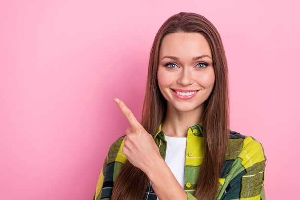 Photo of cheerful positive woman with long hairstyle checkered shirt directing at dental ad empty space isolated on pink color background. - Fotografie, Obrázek