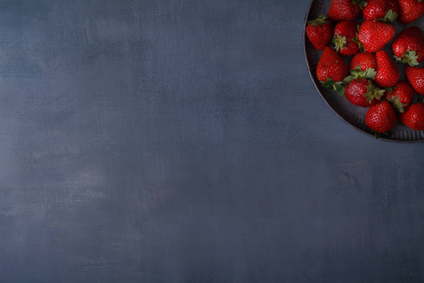 Fresh strawberries in a stylish plate on a dark gray background. Top view with space to copy. - Fotoğraf, Görsel