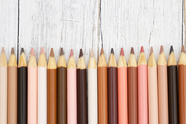 Цветные карандаши цвета кожи мультикультуры на фоне погоды древесины для вашего образования или школьного сообщения - Фото, изображение