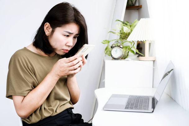 Concept de cyphose avec une vue latérale de la femme asiatique regardant un téléphone mobile avec une posture incorrecte courbée vers l'arrière, la tête vers l'avant et la courbure de la colonne vertébrale - Photo, image