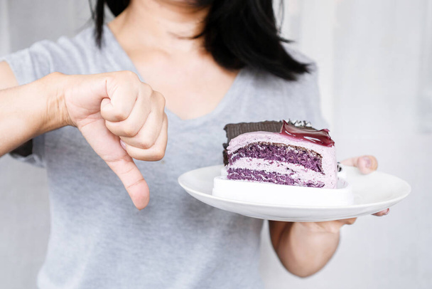 El gesto decidido de la mujer: Rechazar la tentación del azúcar al negarse a disfrutar de pasteles y postres dulces - Foto, imagen