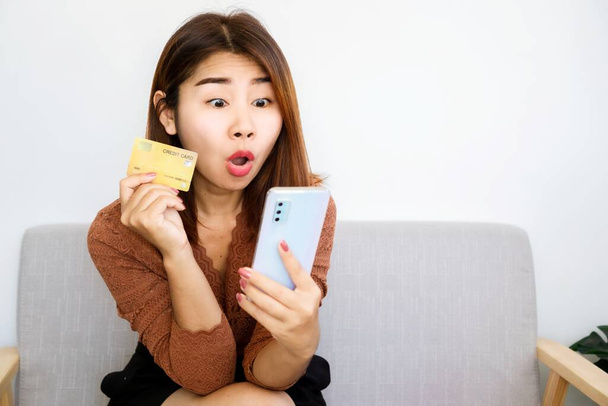 innoissaan shopaholic aasialainen nainen valmis maksamaan myyntiin tuotteita käsi tilalla luottokortti ja matkapuhelin - Valokuva, kuva