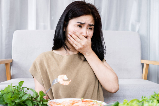 Mujer asiática que experimenta náuseas y vómitos debido a la alergia al camarón - Foto, Imagen