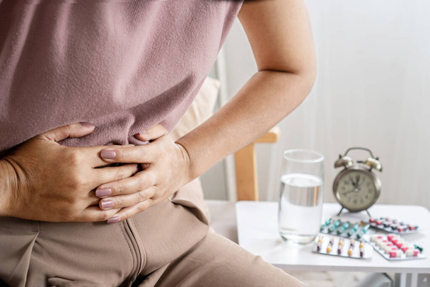 zespół jelita drażliwego koncepcja IBS z kobietą trzymającą ból brzucha mających problemy z układem pokarmowym, takie jak biegunka i zaparcia - Zdjęcie, obraz