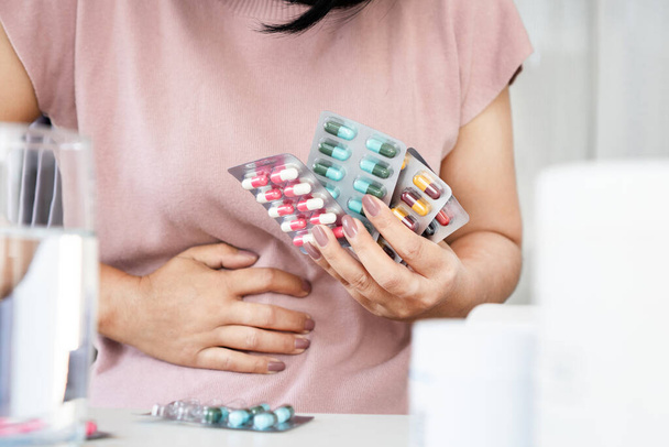 Antibiotic-associated diarrhea (AAD) concept with woman have an upset stomach, side effects from overusing antibiotics medicine often or long-term - Fotoğraf, Görsel