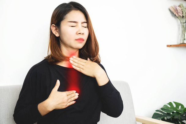 Femme asiatique souffrant de reflux acide ou de reflux gastro-œsophagien (RGO) se sentant mal à l'aise et brûlant poitrine se déplacer vers le cou et la gorge - Photo, image
