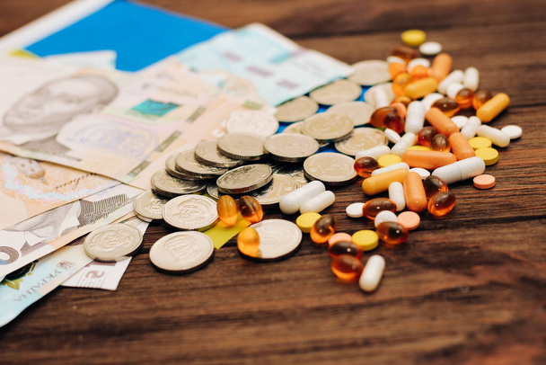 Ukrainian hryvnias with flag of Ukraine with pills and vitamins, healthcare concept. - Foto, Imagen