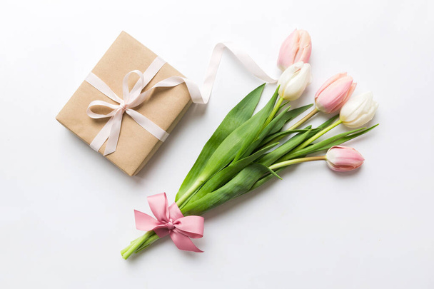ピンクのチューリップの花やギフトや色のテーブルの背景にプレゼントボックス。母の日、誕生日、女性の日、お祝いの概念。テキスト上面ビューのスペース. - 写真・画像