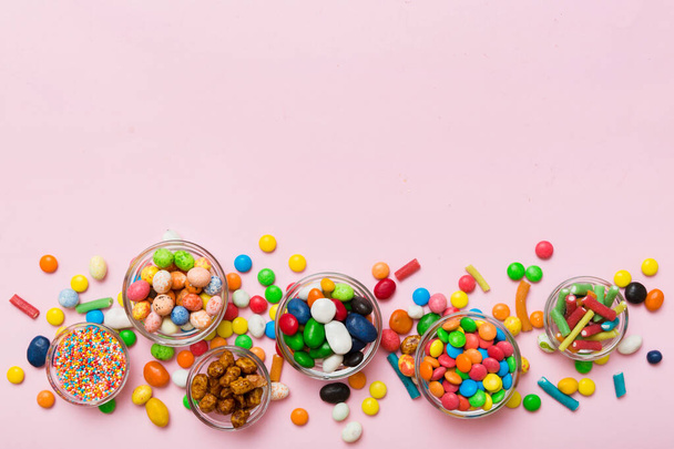 different colored round candy in bowl and jars. Top view of large variety sweets and candies with copy space. - Fotografie, Obrázek
