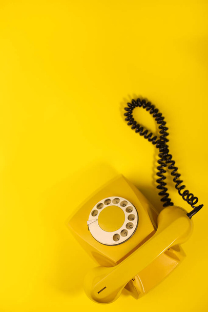 желтый яркий ретро телефон на ярко-желтом фоне. для баннеров, рекламных объявлений, листовок, заставки, обложек, пригласительных билетов и т.д.. - Фото, изображение
