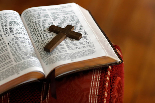 Open bible with a wooden cross. - 写真・画像
