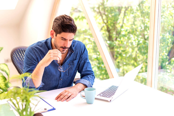 Stressed middle aged businessman sitting at desk and using laptop for work. - Fotó, kép