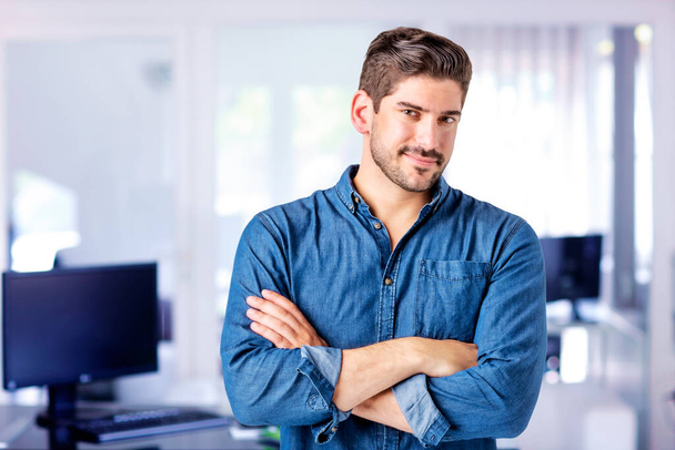 Portrait of confident businessman wearing shirt and standing with arms crossed at the office. - Foto, Bild