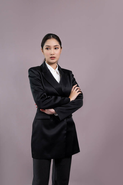 Уверенная молодая деловая женщина стоит на изолированном фоне, позируя в формальном черном костюме. Офис леди или менеджер с умной и профессиональной внешностью. Энтузиазм - Фото, изображение