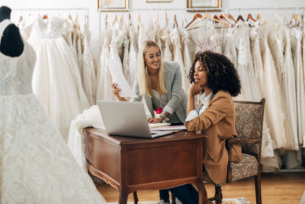 A designer shows new designs to the owner of a wedding dress salon. - Photo, image