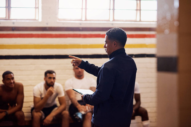 Het soort coaching dat een spel kan veranderen. een rugbycoach die zijn teamspelers toespreekt in een kleedkamer - Foto, afbeelding