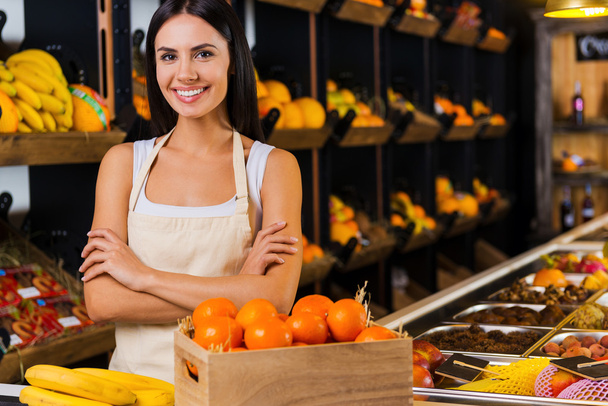 Smiling woman standing in grocery store - Foto, Imagen
