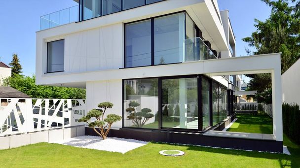 Tyylikäs valkoinen talo avoimella konseptilla. Moderni ylellinen huvila ulkoa. Moderni talo suuret ikkunat ja lasitus. - Valokuva, kuva