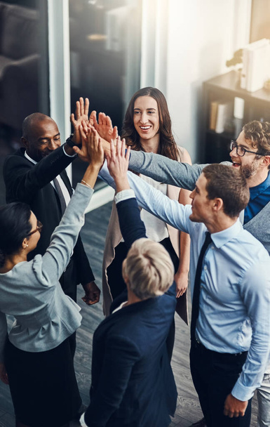 Were going to succeed no matter what. High angle shot of a group of businesspeople high fiving in an office - Foto, immagini