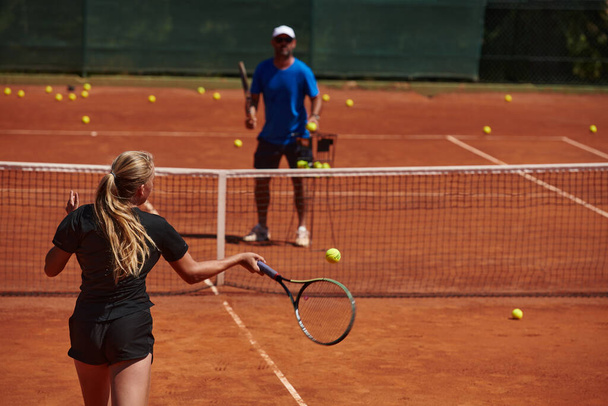A professional tennis player and her coach training on a sunny day at the tennis court. Training and preparation of a professional tennis player. - Foto, immagini