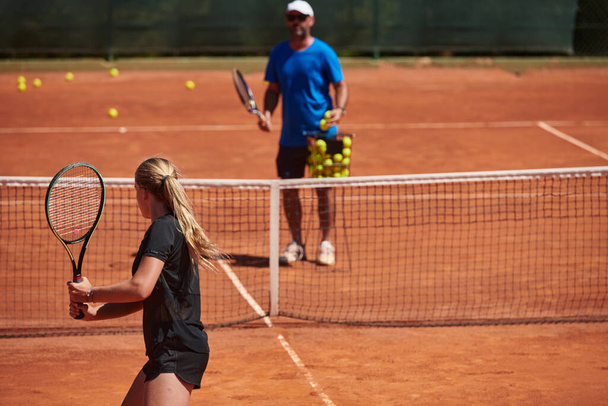 A professional tennis player and her coach training on a sunny day at the tennis court. Training and preparation of a professional tennis player. - Zdjęcie, obraz
