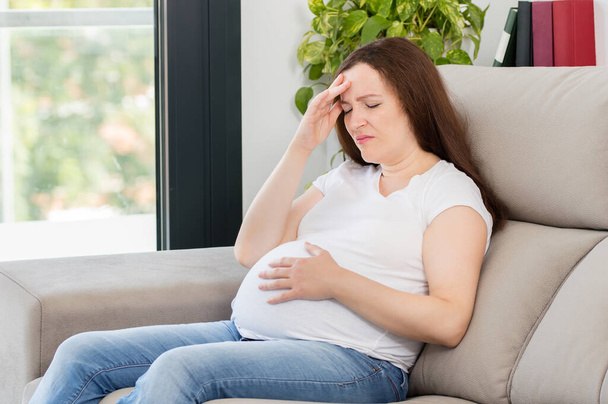 Shot of a pregnant woman suffering headache at home - Fotografie, Obrázek