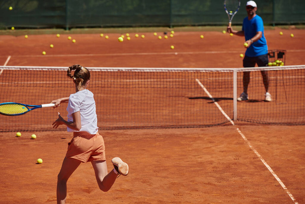 A professional tennis player and her coach training on a sunny day at the tennis court. Training and preparation of a professional tennis player. - Fotó, kép