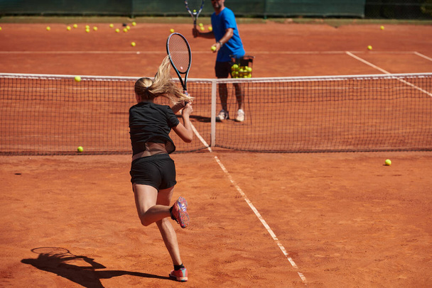 A professional tennis player and her coach training on a sunny day at the tennis court. Training and preparation of a professional tennis player. - Fotó, kép