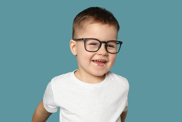 Netter kleiner Junge in Brille auf hellblauem Hintergrund - Foto, Bild