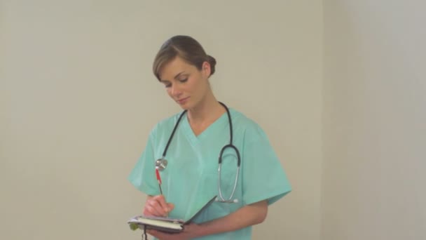 Female doctor taking notes - Filmati, video