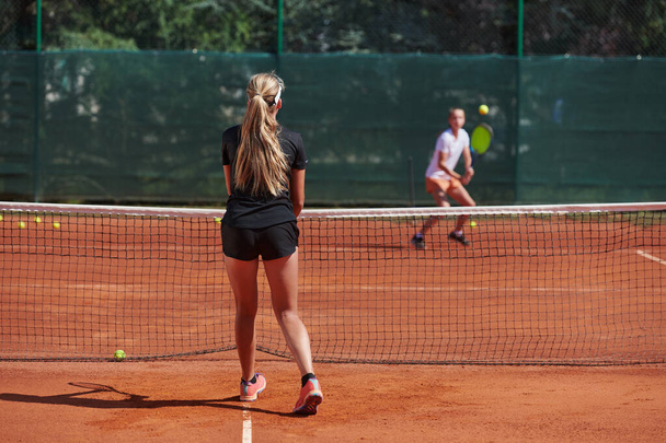 Young girls in a lively tennis match on a sunny day, demonstrating their skills and enthusiasm on a modern tennis court - Foto, imagen