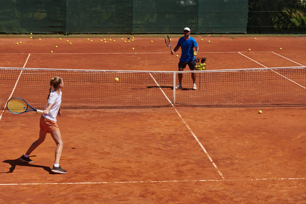 A professional tennis player and her coach training on a sunny day at the tennis court. Training and preparation of a professional tennis player. - 写真・画像