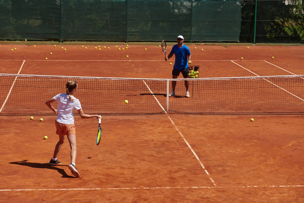 A professional tennis player and her coach training on a sunny day at the tennis court. Training and preparation of a professional tennis player. - Foto, immagini