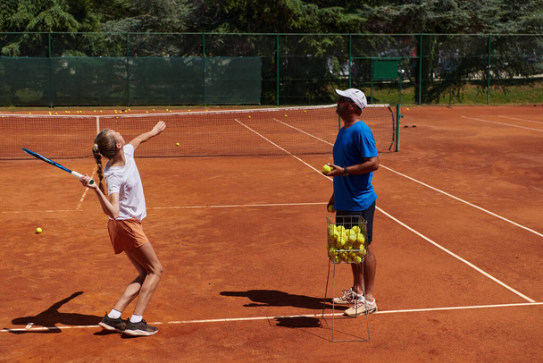 A professional tennis player and her coach training on a sunny day at the tennis court. Training and preparation of a professional tennis player. - Photo, image