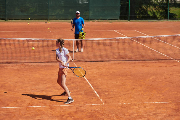 A professional tennis player and her coach training on a sunny day at the tennis court. Training and preparation of a professional tennis player. - 写真・画像