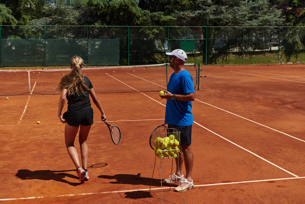 A professional tennis player and her coach training on a sunny day at the tennis court. Training and preparation of a professional tennis player. - Foto, Imagem